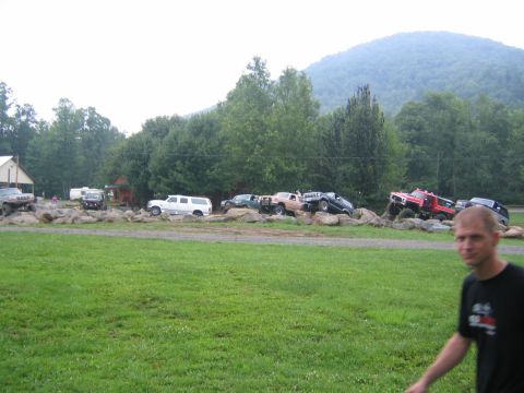 1979 Ford Bronco - Several off-road vehicles navigate a challenging rocky obstacle course under a cloudy sky.