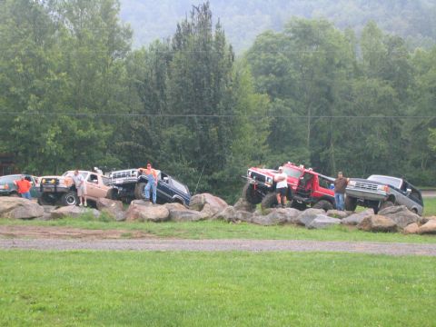 1979 Ford Bronco - Several modified off-road vehicles, including a 1979 Ford Bronco, are positioned on large rocks during an event.