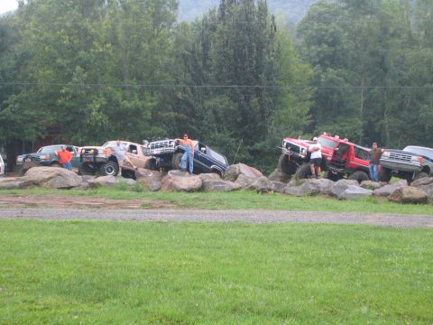 1979 Ford Bronco - Multiple off-road vehicles are navigating a rocky terrain, with spectators present.