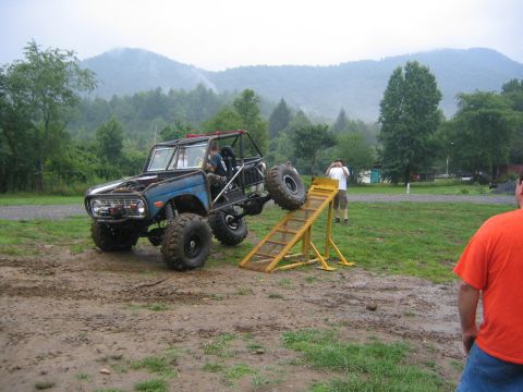 1979 Ford Bronco - A heavily modified 1979 Ford Bronco is shown attempting to ascend a ramp in a muddy outdoor area.