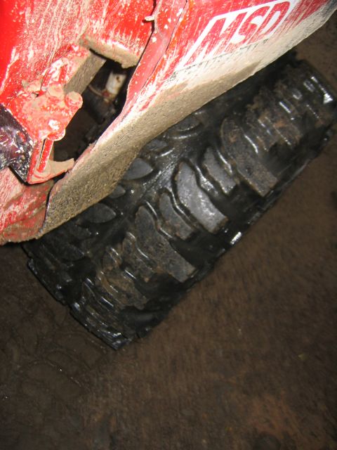 1979 Ford Bronco - The MSD logo is visible on the side of a mud-covered red vehicle near its tire.