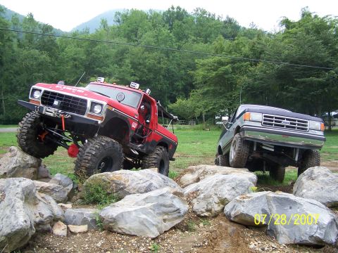 1979 Ford F-150 - Two modified trucks tackle a challenging rock crawling course on a summer day.