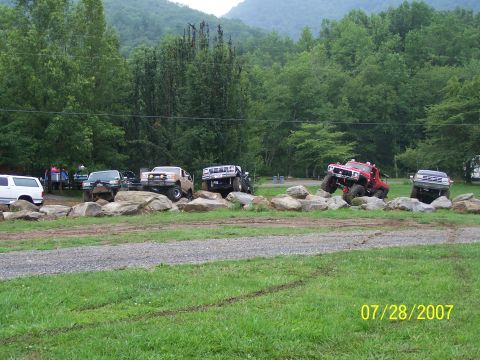 1979 Ford F-150 - Multiple off-road vehicles are positioned on and around large rocks in a natural setting.