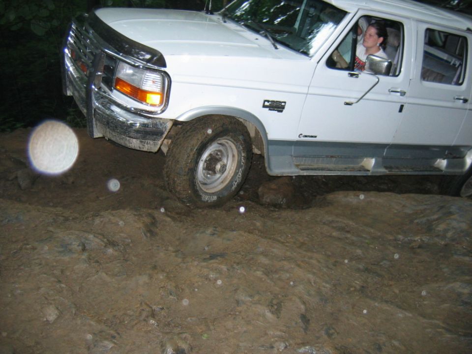 White Ford F-Series truck navigating rocky terrain
