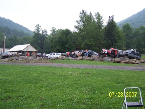 1979 Ford F-150 - Several trucks and SUVs are positioned on large rocks, suggesting an off-road event or challenge, dated 07/28/2007.