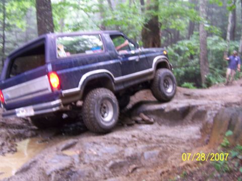1979 Ford F-150 - A dark blue 1979 Ford Bronco navigates a challenging rocky off-road course.