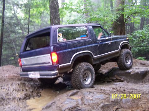 1979 Ford F-150 - Ford Bronco navigating a muddy trail with large tires.