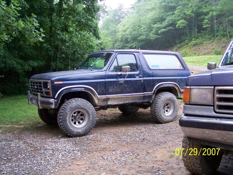 1979 Ford F-150 - A dark blue 1978 Ford Bronco sits on a gravel surface next to another vehicle.