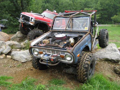 1995 Ford Bronco - Two heavily modified Ford Broncos navigate a rocky obstacle course.