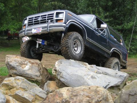1995 Ford Bronco - This lifted Ford Bronco is shown off-roading over a rocky terrain.
