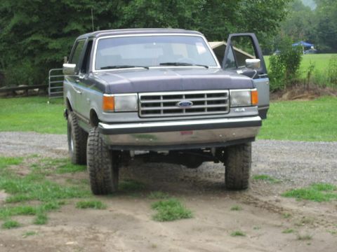 1995 Ford Bronco - This lifted 1995 Ford Bronco features off-road tires and a two-tone paint scheme, seen here from the front.