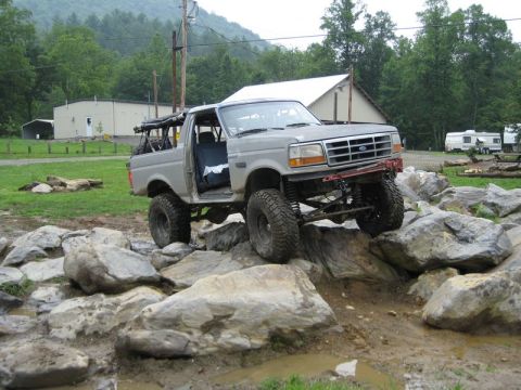 1995 Ford Bronco - This heavily modified 1992 Ford Bronco navigates a challenging rocky course, demonstrating its off-road capabilities.