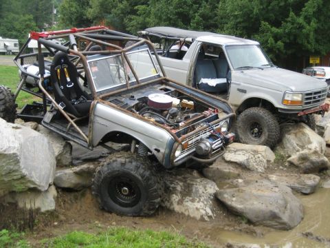1995 Ford Bronco - Two heavily modified Ford Broncos navigate a rocky obstacle course.