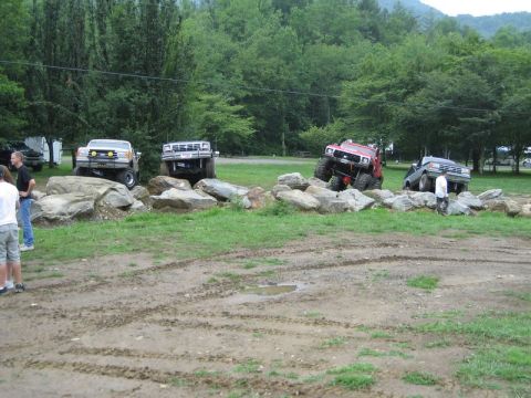 1995 Ford Bronco - Multiple off-road vehicles tackle a challenging rock crawling course during an event.