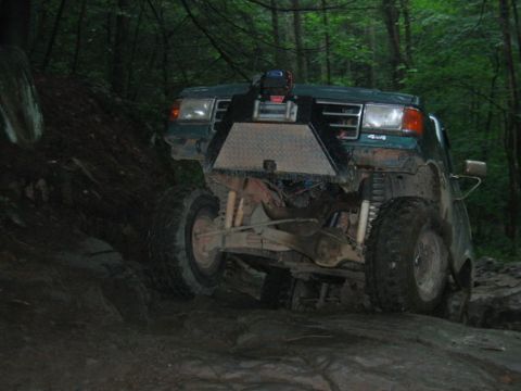 1979 Ford F-150 - This modified truck navigates a rocky trail in a wooded area.
