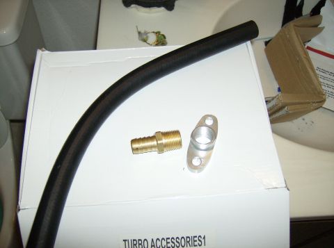 1996 Ford Probe - A black hose and brass fittings are laid out on a white box labeled 'TURBO ACCESSORIES1'.
