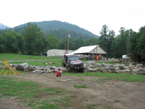 1995 Ford C-350 (Centurion Conversions) - A modified off-road vehicle attempts to traverse a rocky obstacle course with a child on a toy nearby.