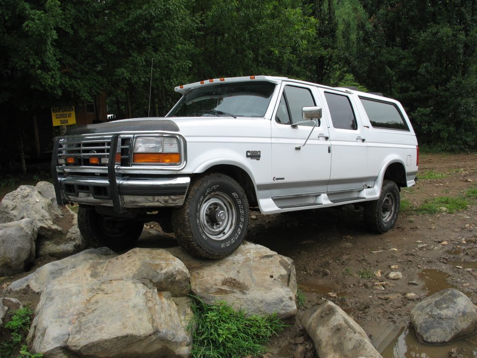 1995 Ford C-350 (Centurion Conversions) parked on rocks with a brush guard