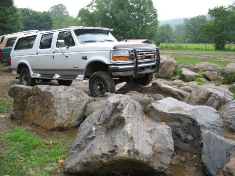 1995 Ford C-350 (Centurion Conversions) - White Ford C-350 SUV carefully maneuvers through a rocky obstacle course.