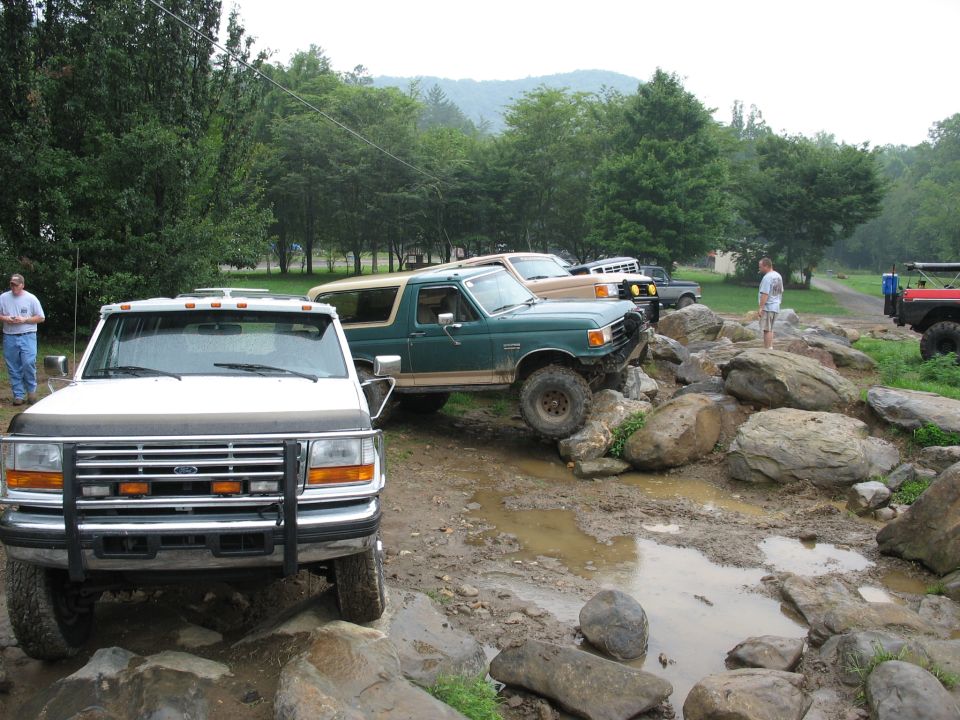 White 1995 Ford F-Series truck front view, off-roading with other vehicles
