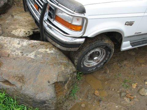 1995 Ford C-350 (Centurion Conversions) - White Ford truck navigating a rocky, muddy obstacle course.