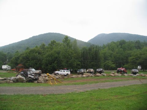 1995 Ford C-350 (Centurion Conversions) - Off-road vehicles tackle a challenging rock obstacle course in a scenic, mountainous area.