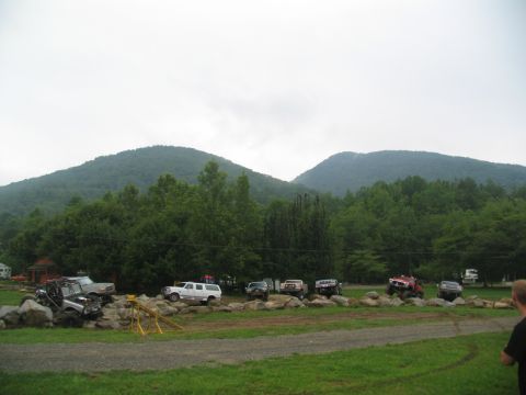 1995 Ford C-350 (Centurion Conversions) - Off-road vehicles are staged on a rocky course with a mountainous backdrop.
