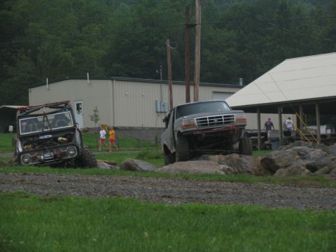 1995 Ford C-350 (Centurion Conversions) - Two modified trucks, a Ford C-350 and a Bronco, tackle a rocky obstacle course.