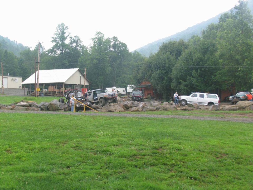 Off-road vehicles on rocks, white SUV on right, silver truck on left