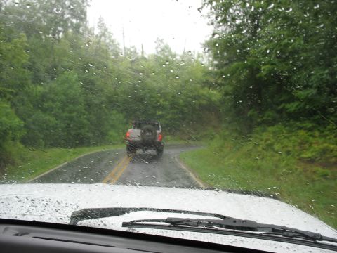 1995 Ford C-350 (Centurion Conversions) - Driving on a winding road in the rain, following another vehicle.