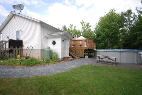 1996 Ford Bronco - A backyard scene shows a house, deck, pool, and picnic table under a cloudy sky.