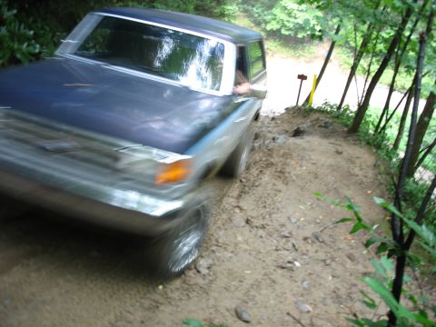 1995 Ford C-350 (Centurion Conversions) - Pickup truck navigates a challenging dirt path through a forest.