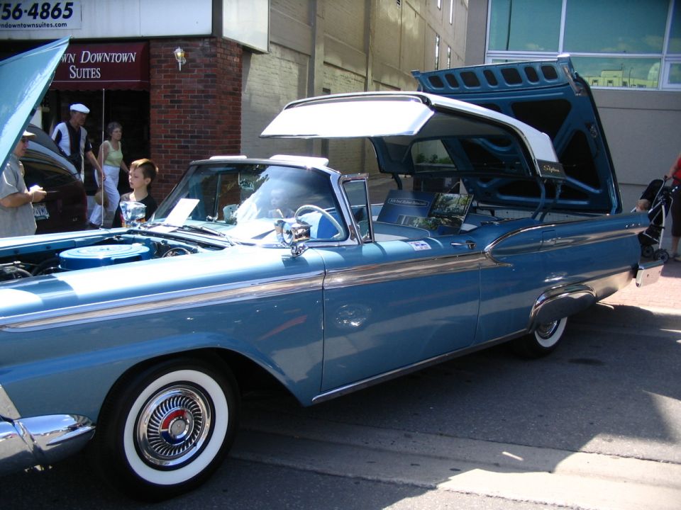 Blue convertible with hood and trunk open. Whitewall tires and chrome trim visible