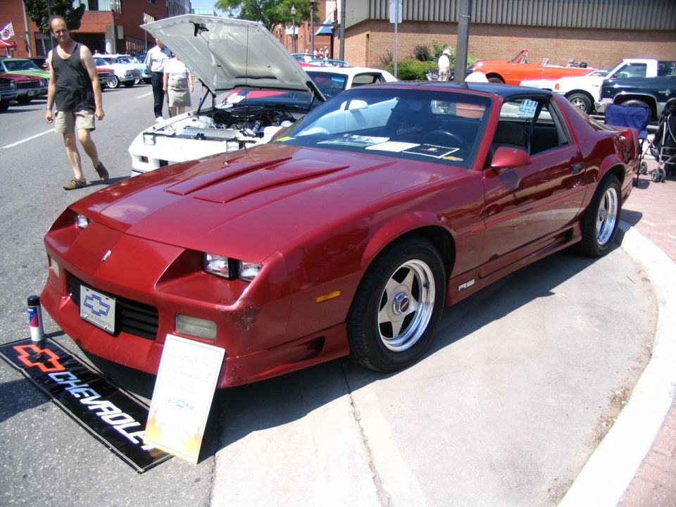 Red 1980s Chevrolet Camaro IROC-Z with a black T-top roof and aftermarket wheels