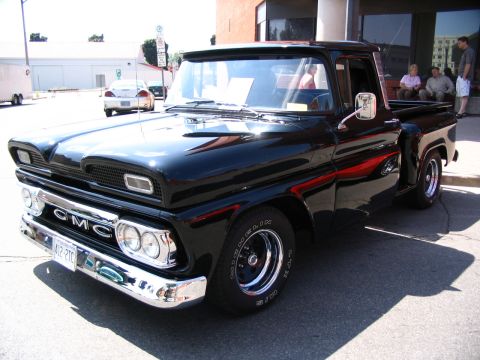 1993 Ford Taurus - This classic black GMC pickup truck features a prominent chrome grille and bumper, with a visible license plate.