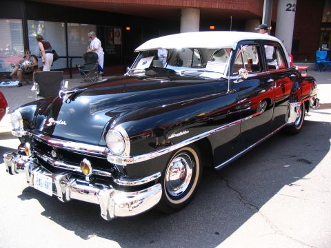 1993 Ford Taurus - A classic black and white two-tone car with extensive chrome detailing is parked at an outdoor event.