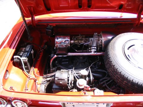 1993 Ford Taurus - The engine bay of a red car shows a V8 engine, spare tire, and battery, battery, with watermarks at the bottom.