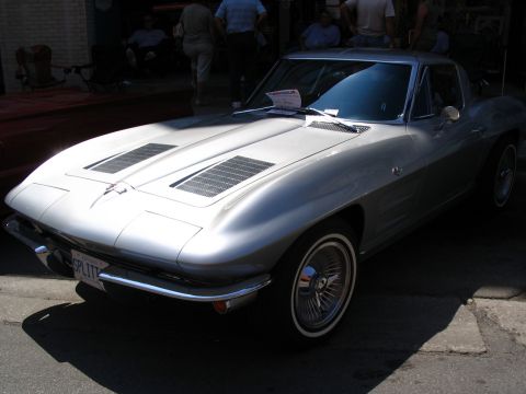 1993 Ford Taurus - A classic silver 1963 Chevrolet Corvette Sting Ray coupe is parked outdoors, its iconic split rear window and wire wheels.
