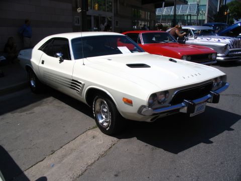 1993 Ford Taurus - A white Dodge Challenger is parked on a street, with other vintage cars visible in the background.