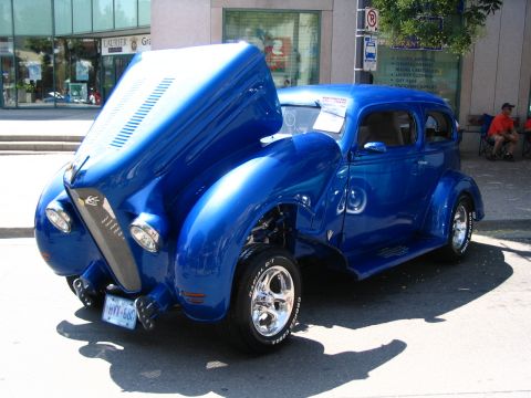 1993 Ford Taurus - A custom blue hot rod is displayed with its hood open, revealing the engine bay and chrome accents.