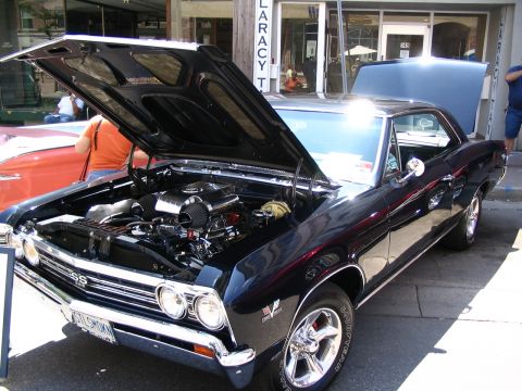 1993 Ford Taurus - A black 1967 Chevrolet Chevelle SS is displayed with its hood open, revealing a powerful V8 engine.