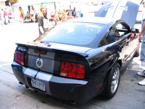 1993 Ford Taurus - Rear view of a black 2007 Ford Mustang Shelby GT500 at a car show, hood is open.