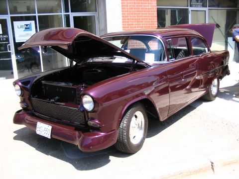 1993 Ford Taurus - A custom 1955 Chevrolet sedan is displayed with its hood and trunk open at a car show.