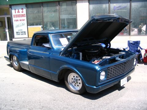 1993 Ford Taurus - This blue pickup truck, likely from the late 1960s or early 1970s, is displayed with its hood open, revealing the engine bay.