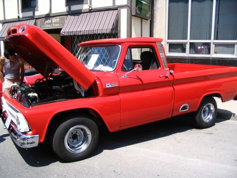 1993 Ford Taurus - A classic red pickup truck is displayed with its hood open, revealing the engine compartment.