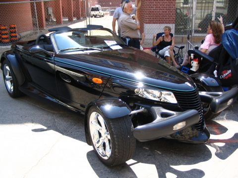 1993 Ford Taurus - A black convertible with a unique retro design is displayed at a car show.
