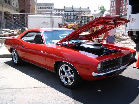 1993 Ford Taurus - A red muscle car is displayed with its hood open, revealing the engine and shaker scoop.