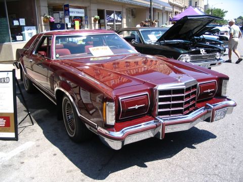 1993 Ford Taurus - This maroon coupe, likely from the late 1970s or early 1980s, is displayed at a car show.
