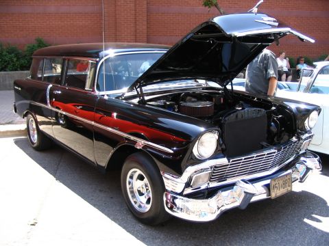 1993 Ford Taurus - This black station wagon, likely a 1956 model, is displayed with its hood open at a car show.