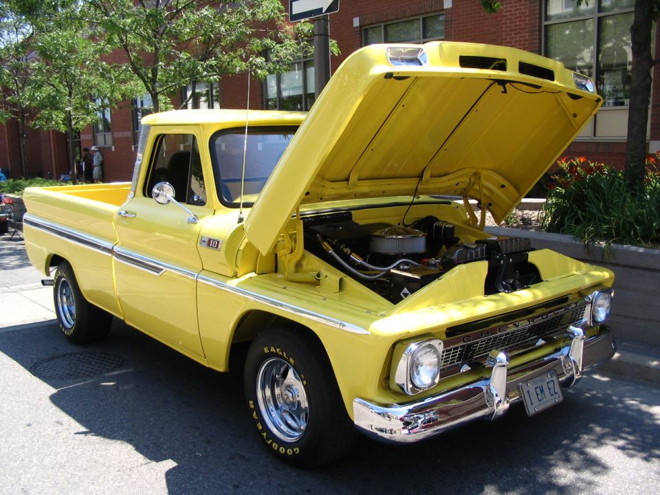 Yellow 1966 Chevrolet C10 pickup truck, hood open, showing engine. Chrome grille and bumpers